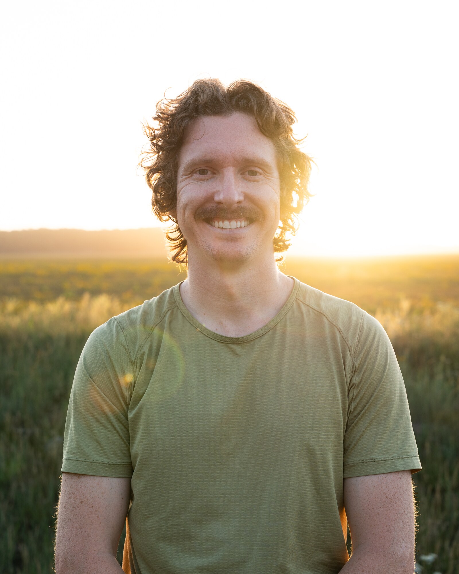 Austin Corbett smiles outdoors in warm evening light.