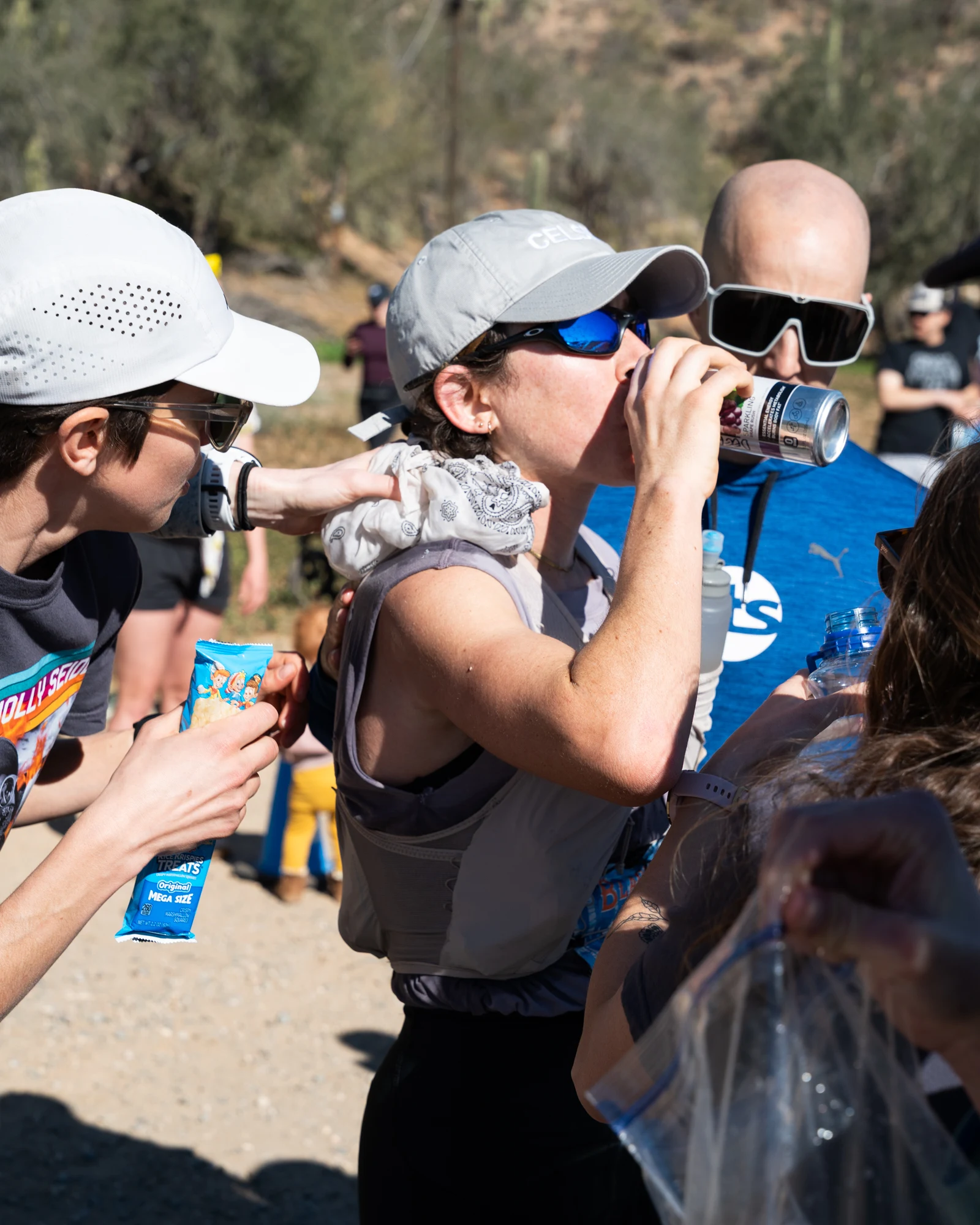 Molly Seidel drinks from a bottle as supporters gather around her.