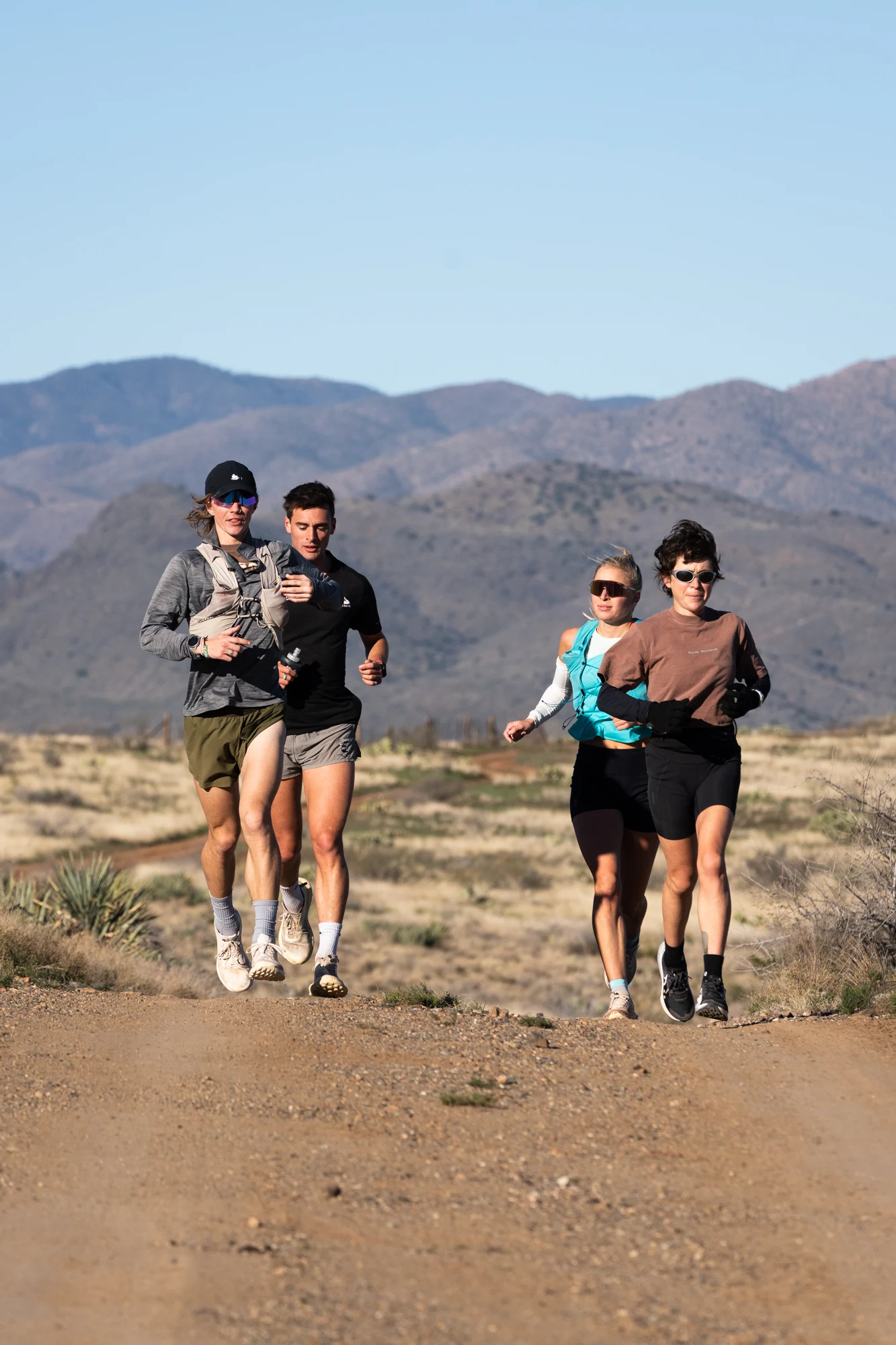 Four Ponderosa Pirates runners move together on a desert trail.