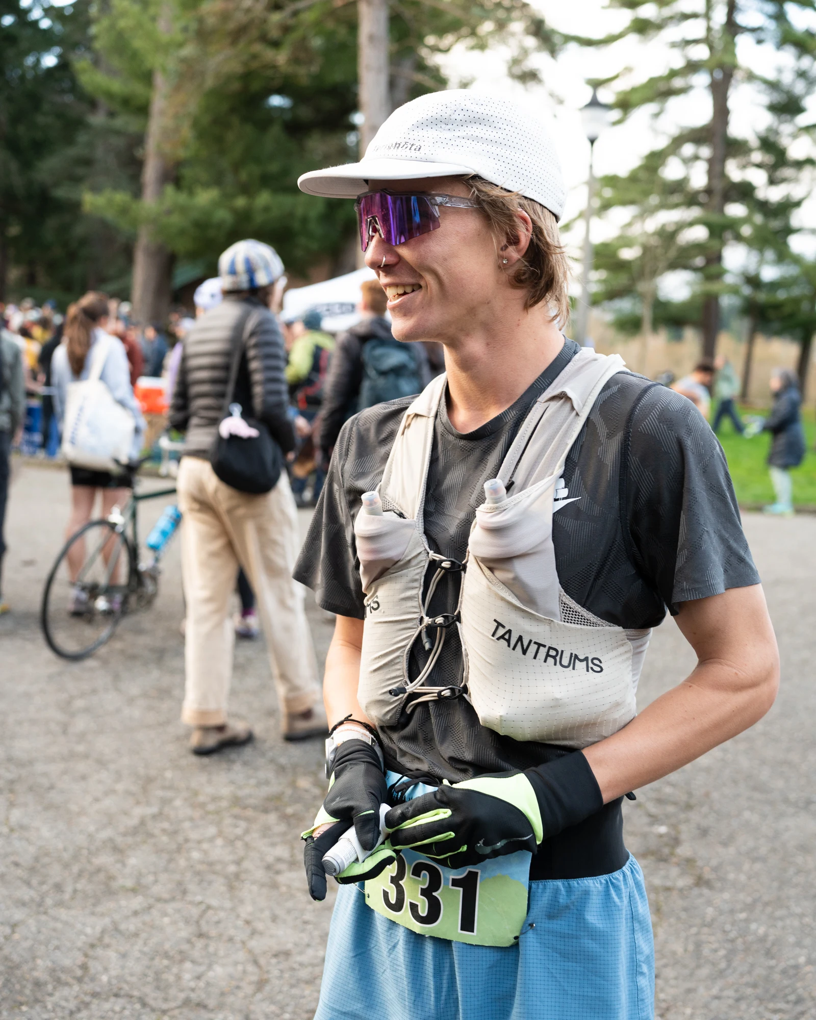 A Ponderosa Pirates runner in a hydration vest smiles near a race finish.