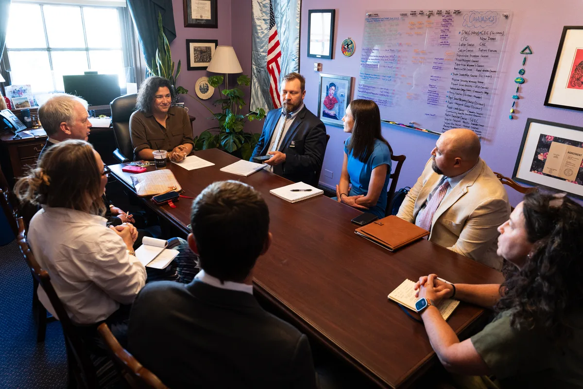 Outdoor Alliance advocates sit around a desk during a congressional office meeting.