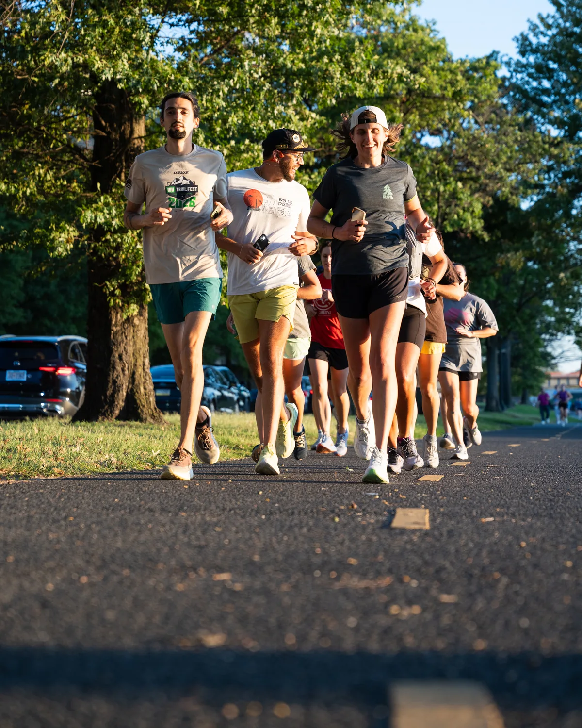 Runners move together along a tree-lined path in Washington, D.C.