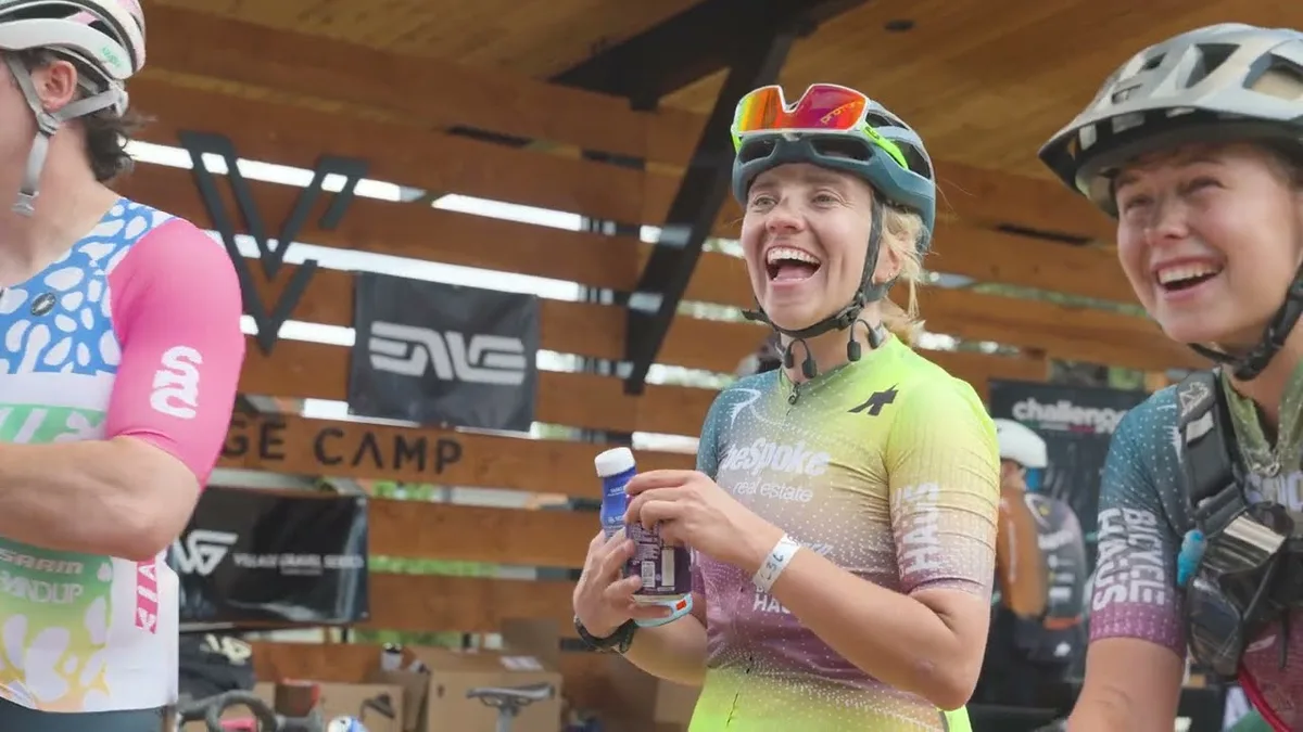 Helmeted cyclists smiling at the Village Gravel race venue.